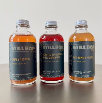 The Still Bar Tasting Flight — three non-alcoholic craft cocktail bottles