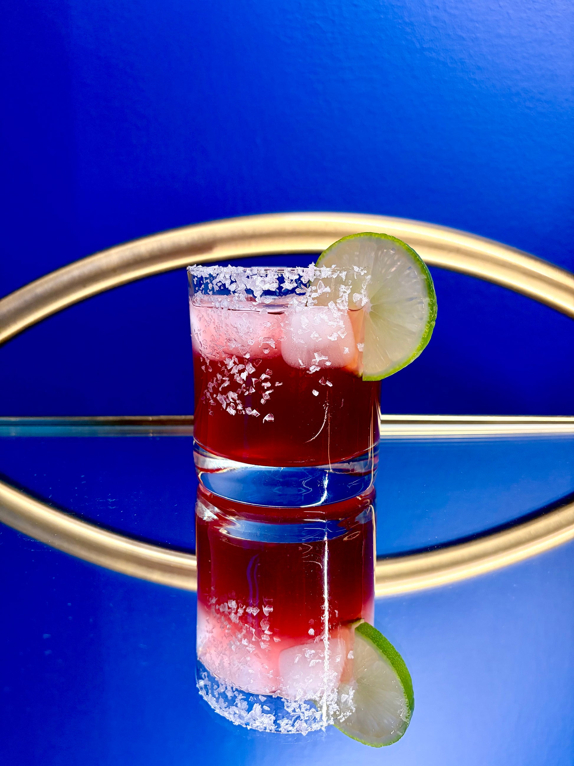 Cocktail with lime wedge on a blue background