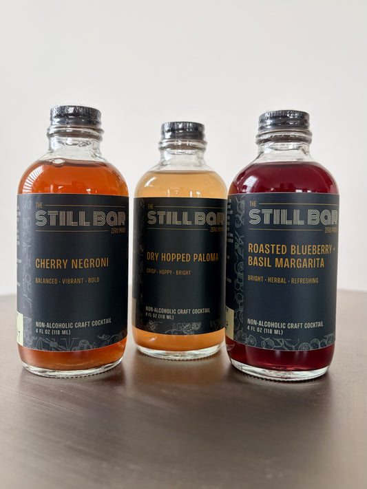 The Still Bar Tasting Flight — three non-alcoholic craft cocktail bottles