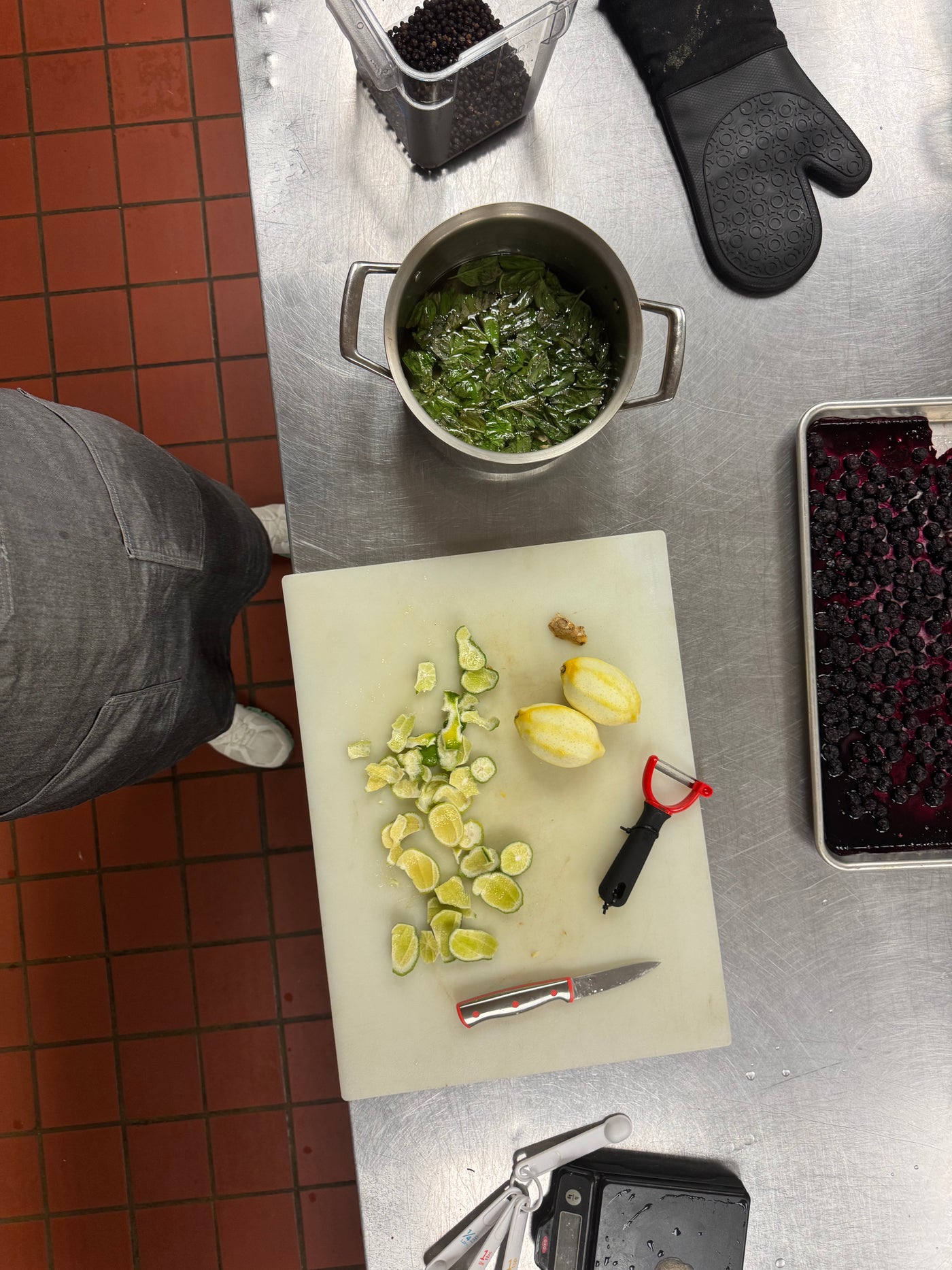 Person preparing food in a kitchen with a cutting board, knife, and ingredients.