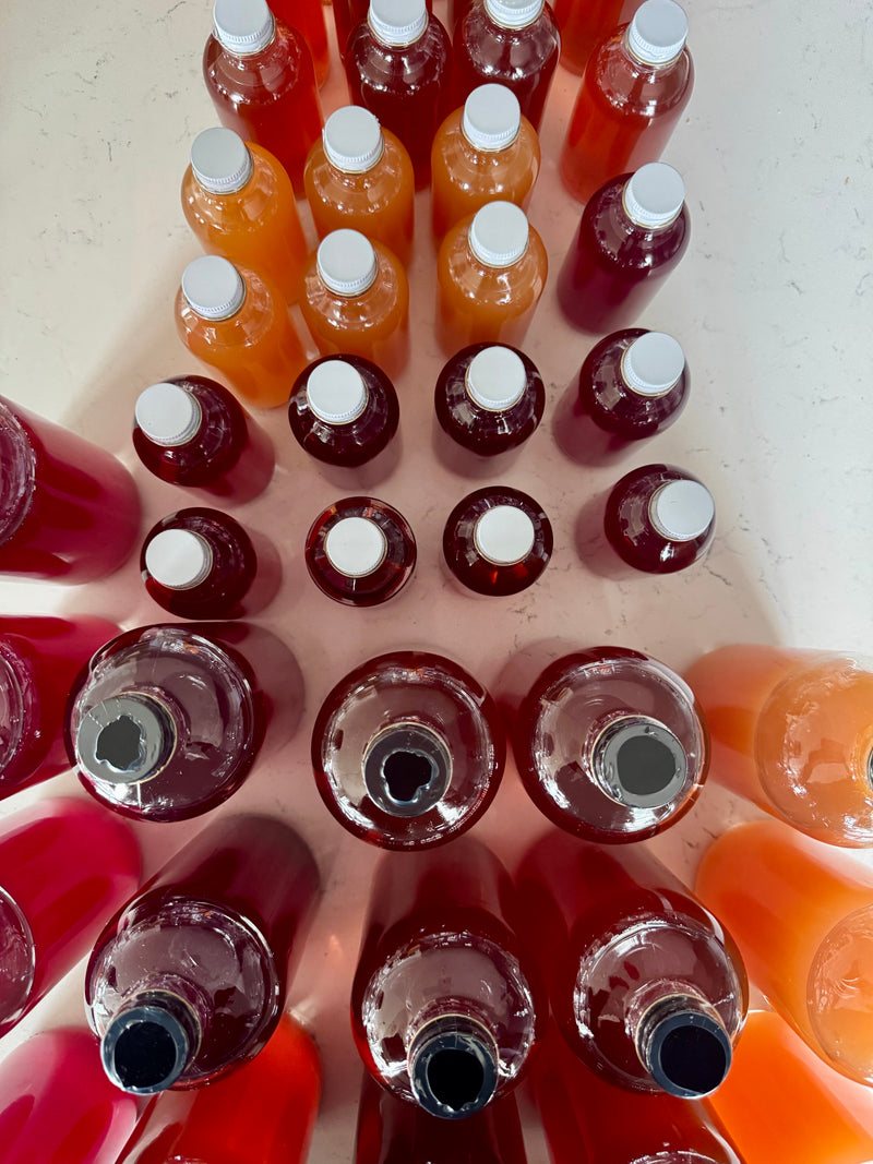 Assorted bottles of beverages arranged on a light surface.